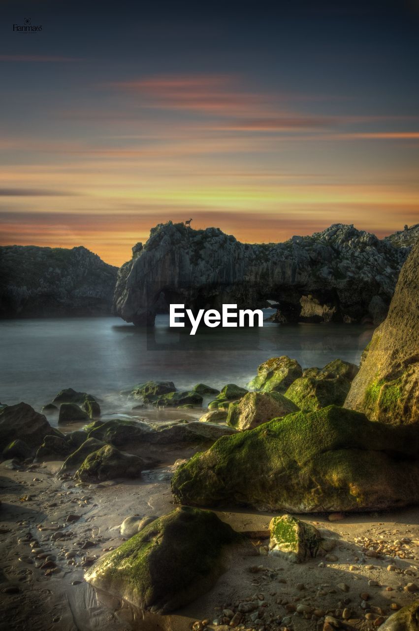 Geological formations at sunset on the cuevas del mar beach in llanes, asturias, spain.