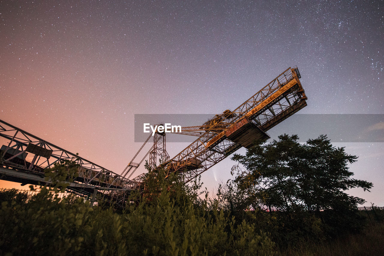 Low angle view of crane against sky at night