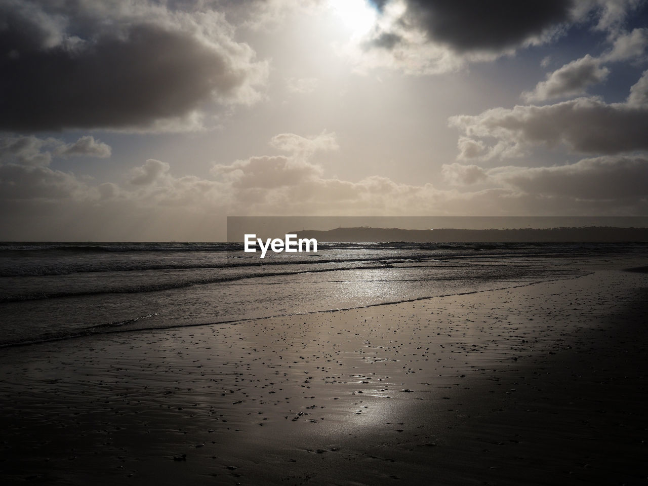 Scenic view of calm sea against cloudy sky