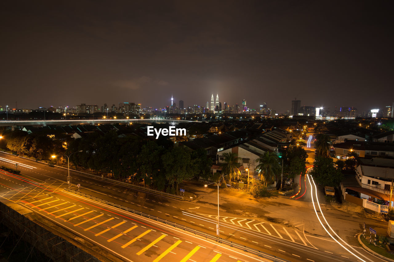 HIGH ANGLE SHOT OF ILLUMINATED CITYSCAPE AGAINST CLEAR SKY