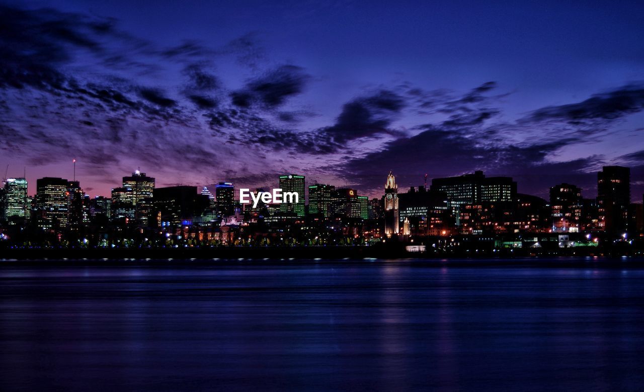 Illuminated city by st lawrence river against sky at night