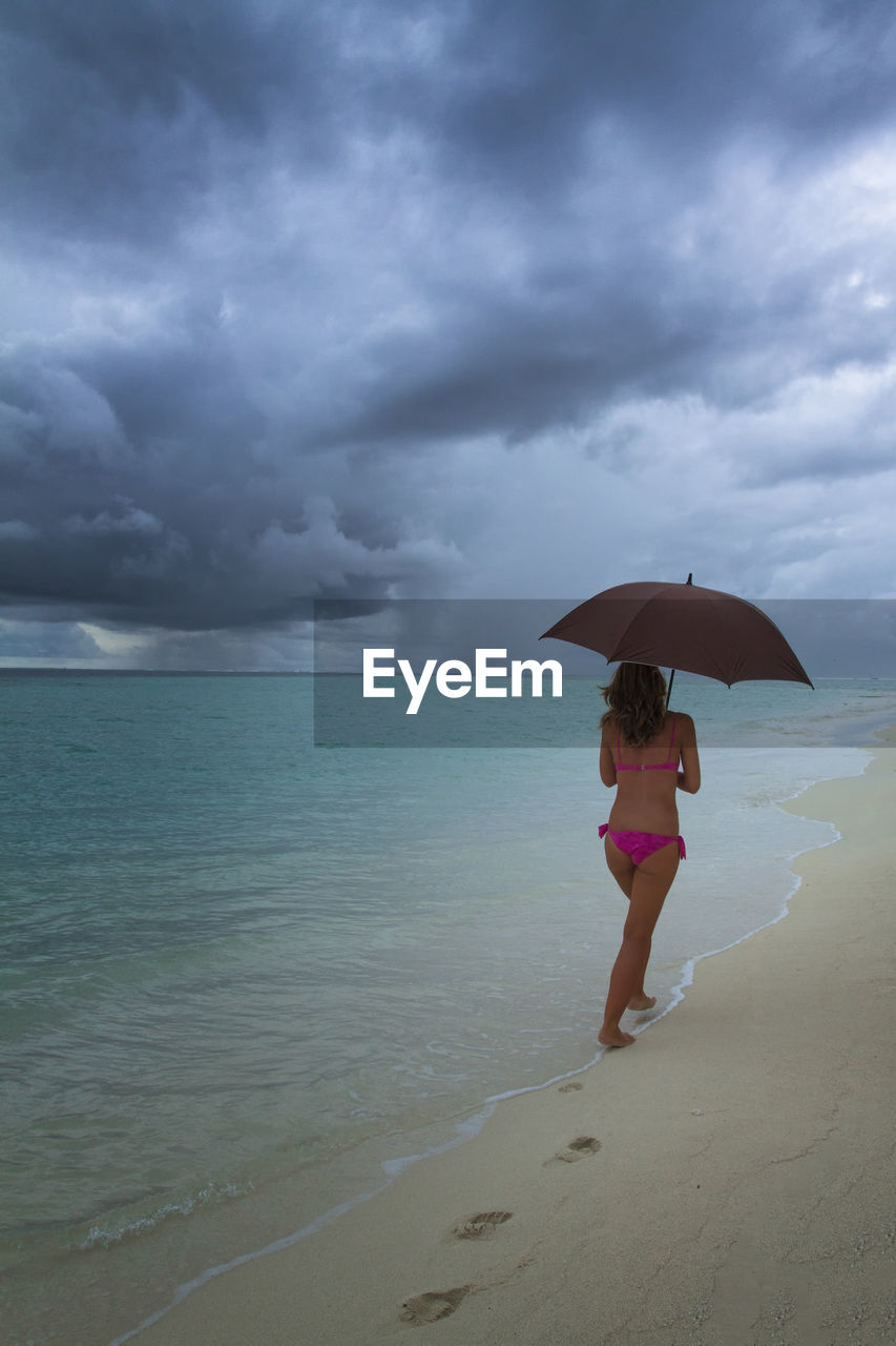 FULL LENGTH OF MAN IN SEA AGAINST SKY