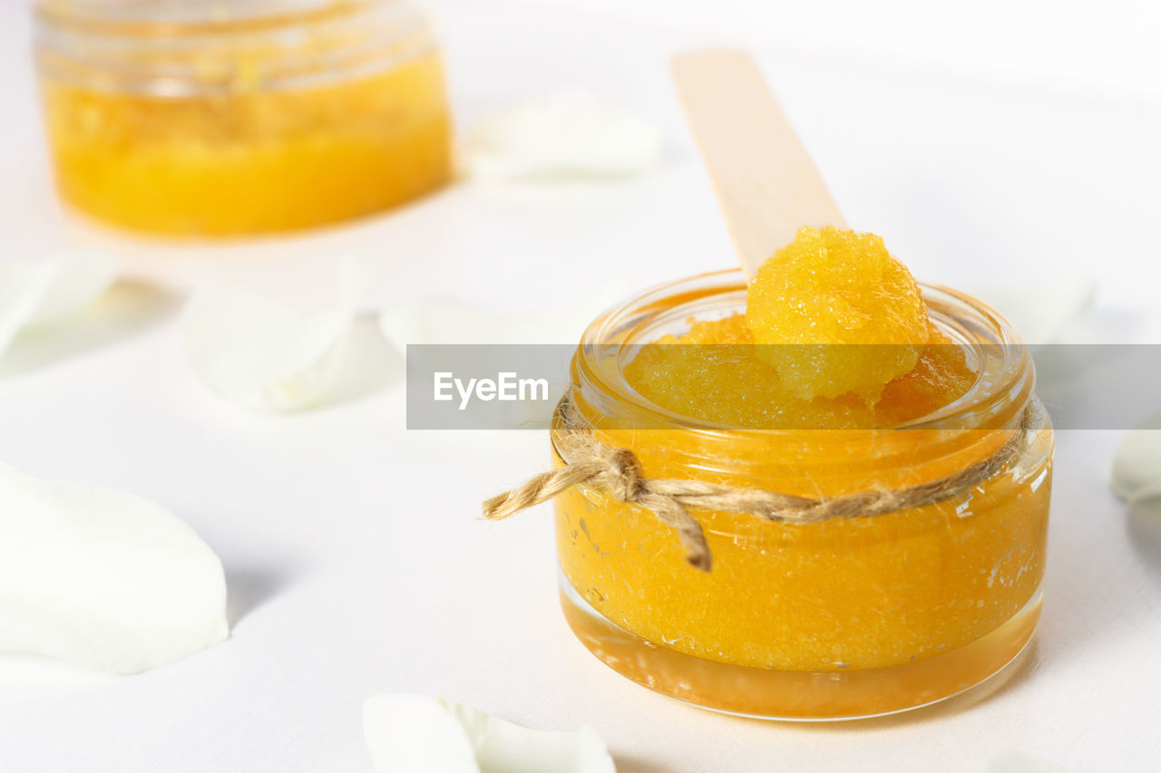 Mango sugar scrub on white wooden background with fruits. home remedy for cleansing the skin