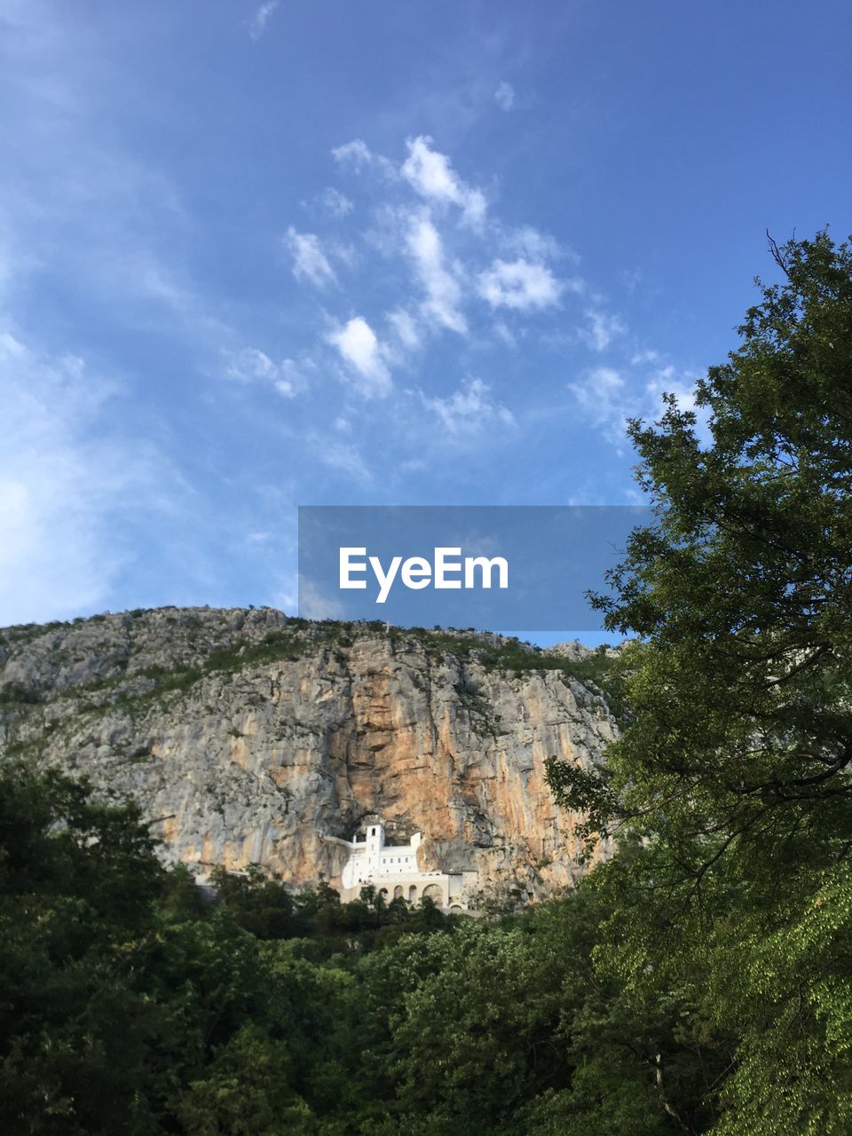 Distant view of ostrog monastery by rock formations against sky