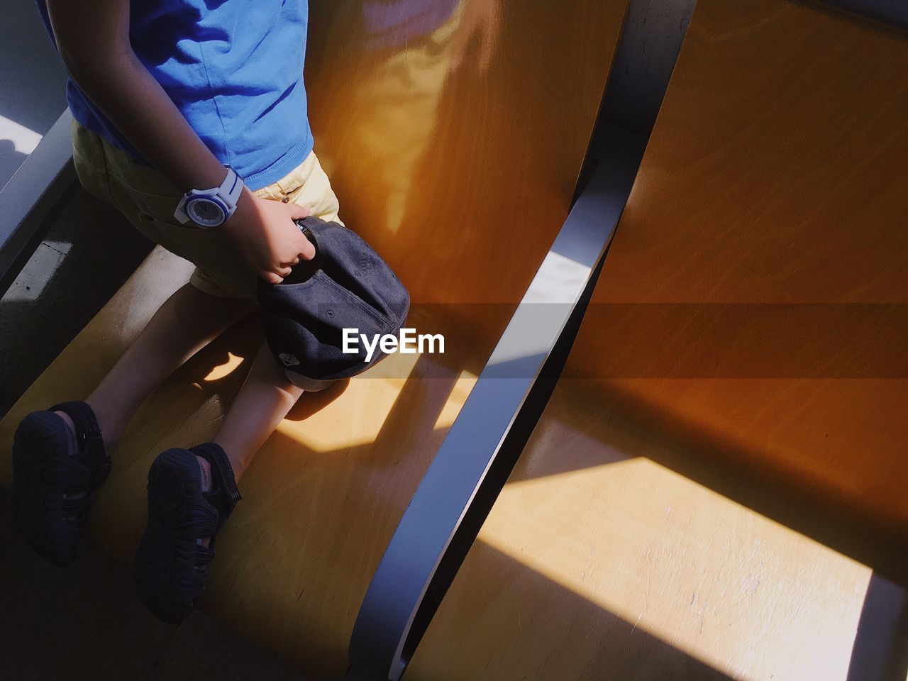 HIGH ANGLE VIEW OF BOY SITTING ON HARDWOOD FLOOR