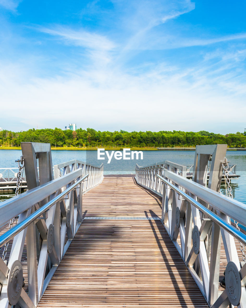 Empty pier over lake against sky