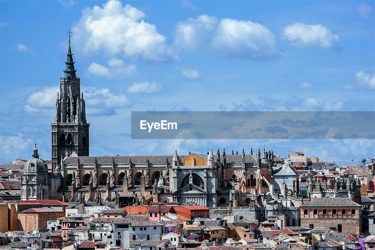 Buildings against cloudy sky in city on sunny day