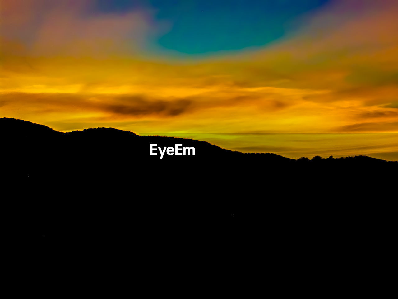 SCENIC VIEW OF SILHOUETTE MOUNTAINS AGAINST DRAMATIC SKY