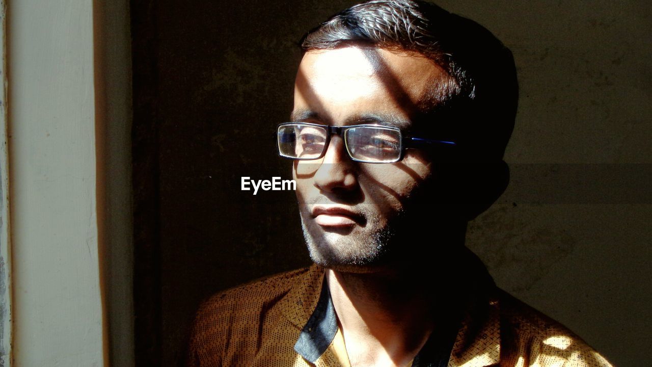 Sunlight falling on young man wearing eyeglasses