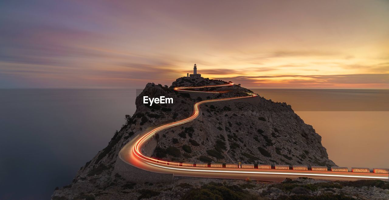 high angle view of man standing on mountain against sky during sunset