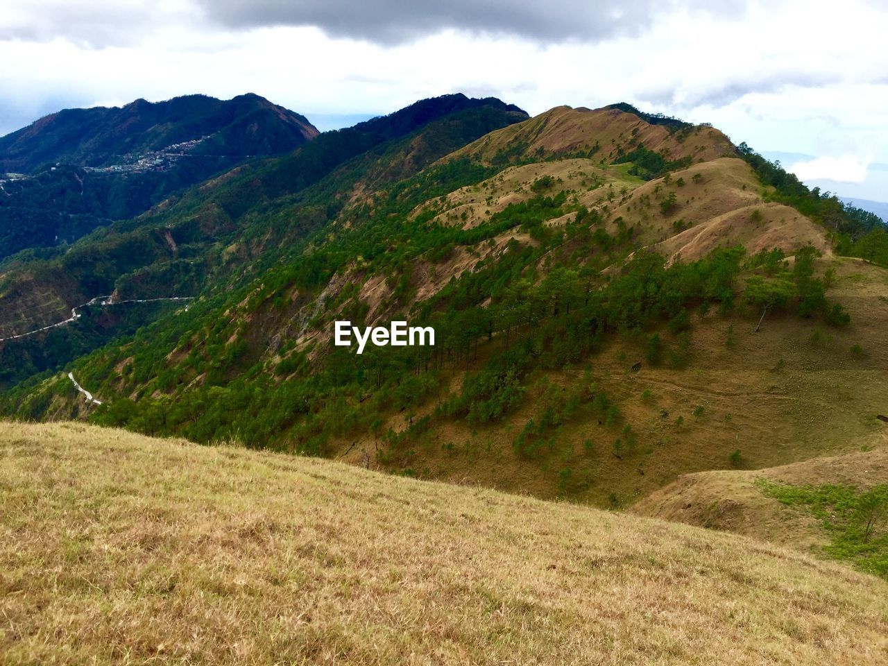 SCENIC VIEW OF MOUNTAINS AGAINST CLOUDY SKY