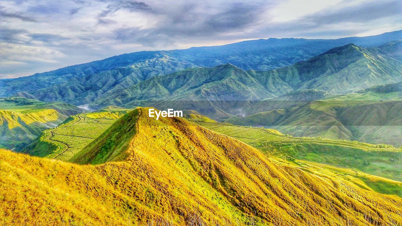 Scenic view of mountains against cloudy sky