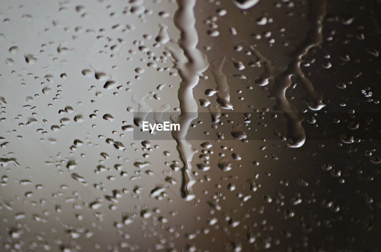 FULL FRAME SHOT OF RAINDROPS ON GLASS