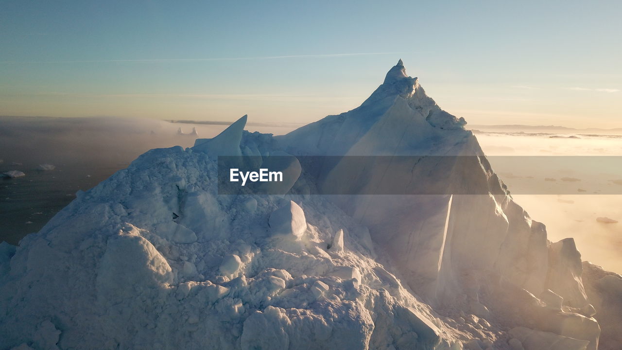 SCENIC VIEW OF SNOWCAPPED MOUNTAINS AGAINST SKY DURING SUNSET