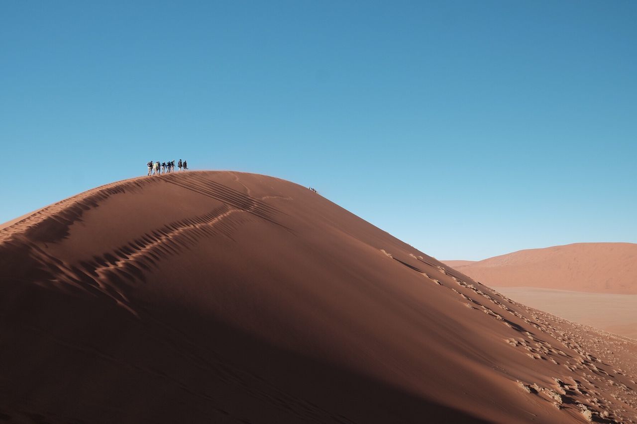 Scenic view of desert against clear blue sky