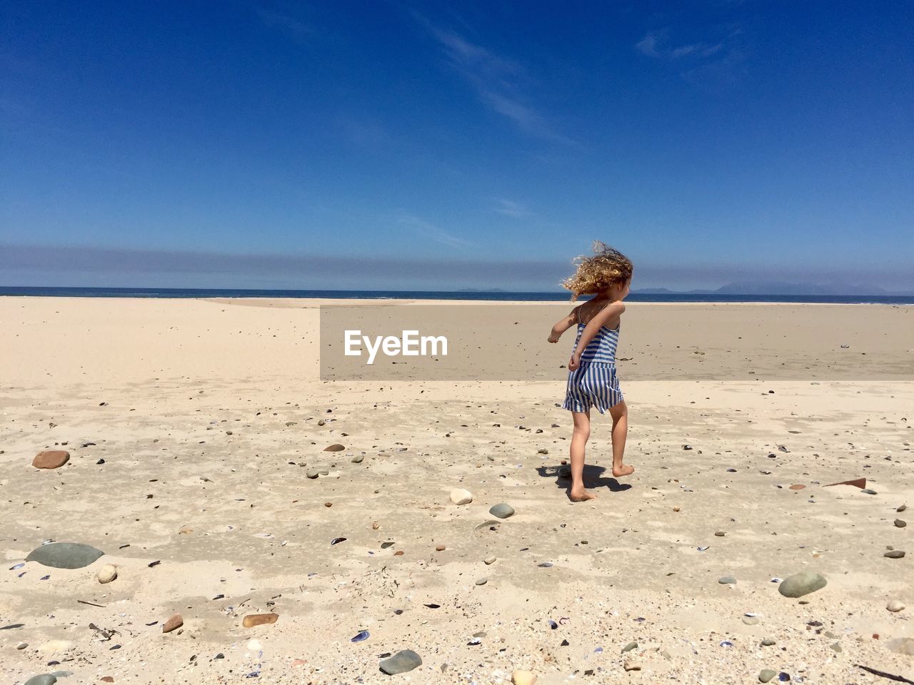 Full length of girl running on beach against sky