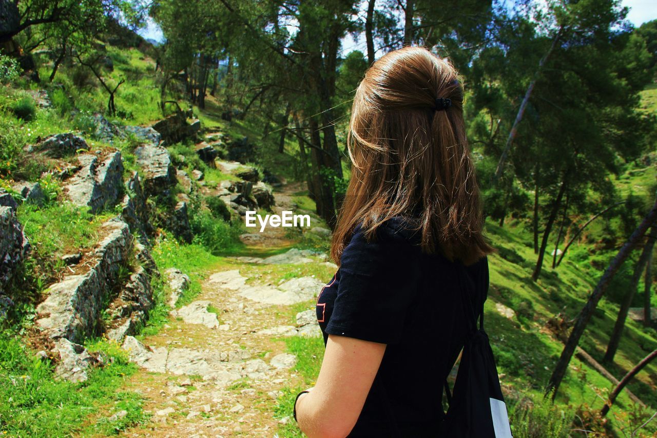 Side view of woman standing in forest