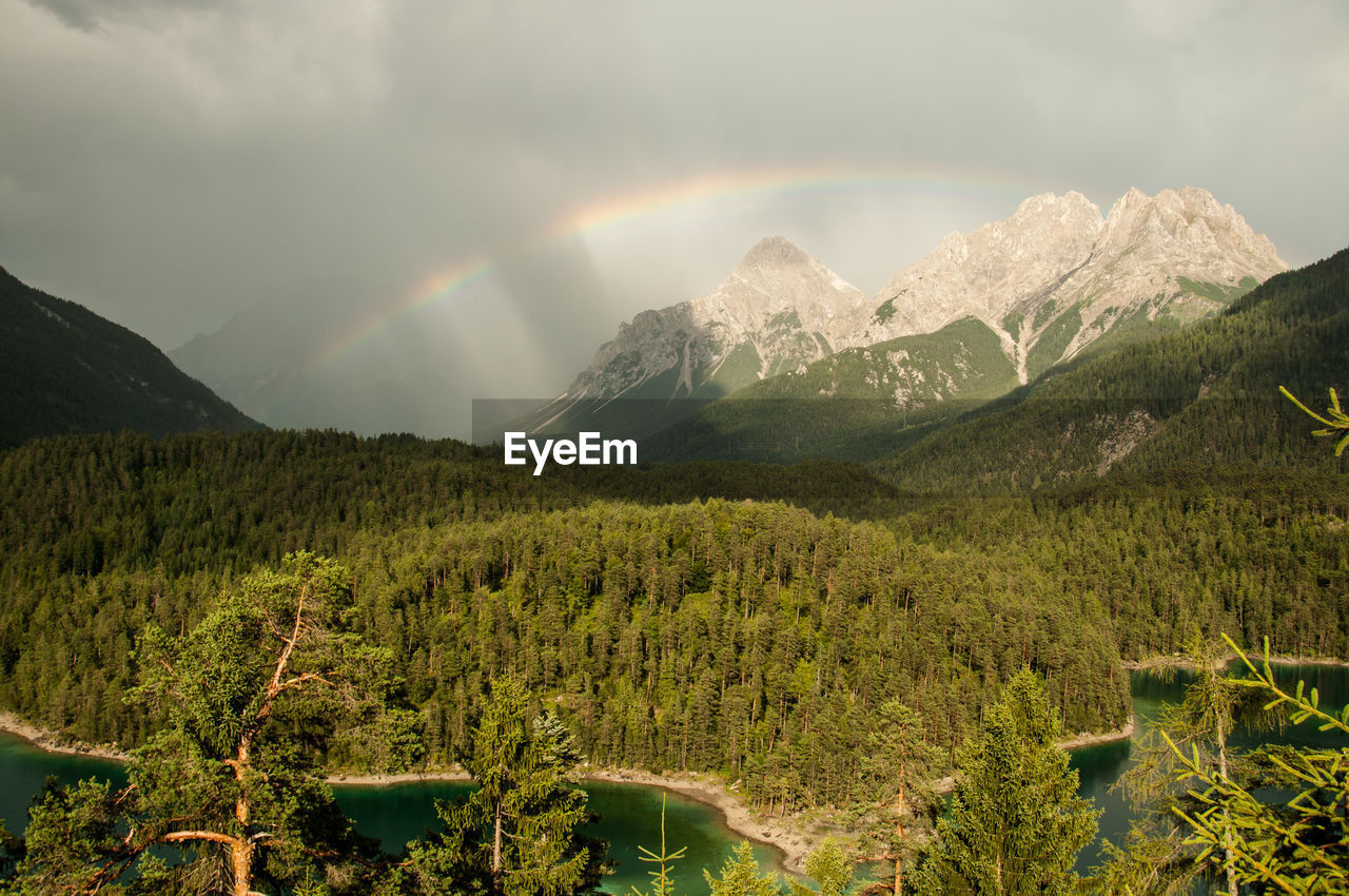 Scenic view of rainbow over mountains against sky