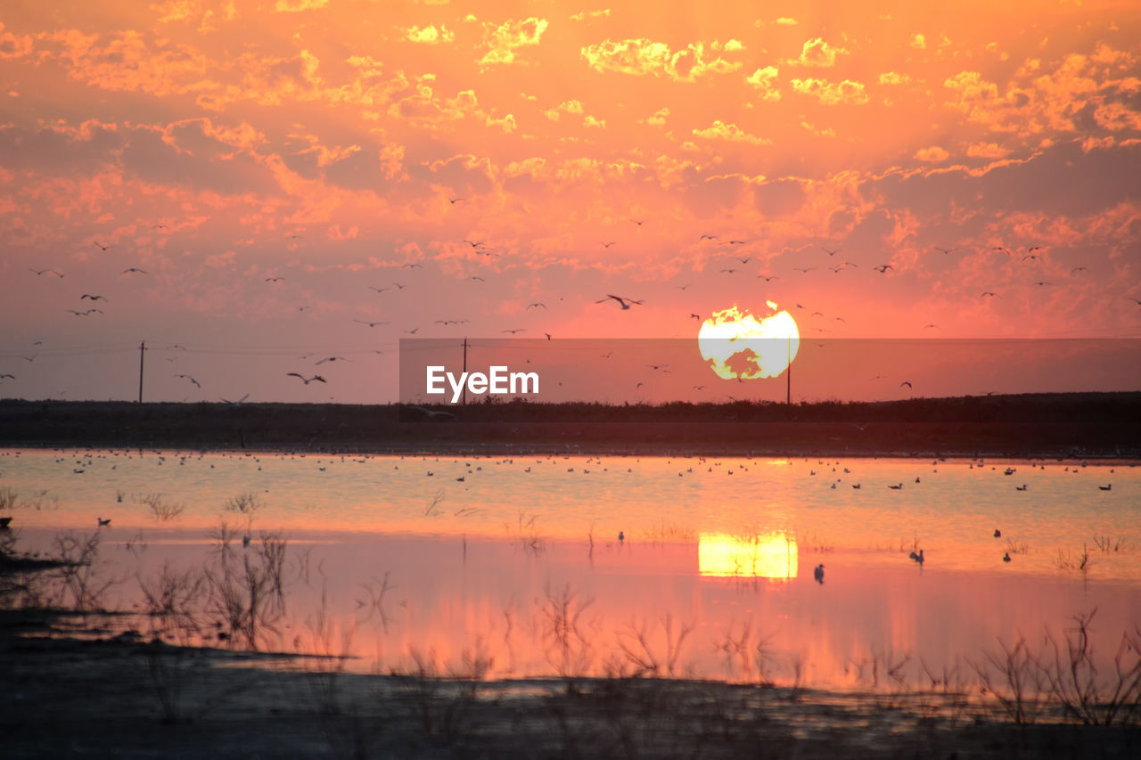 SCENIC VIEW OF LAKE AGAINST ORANGE SKY DURING SUNSET