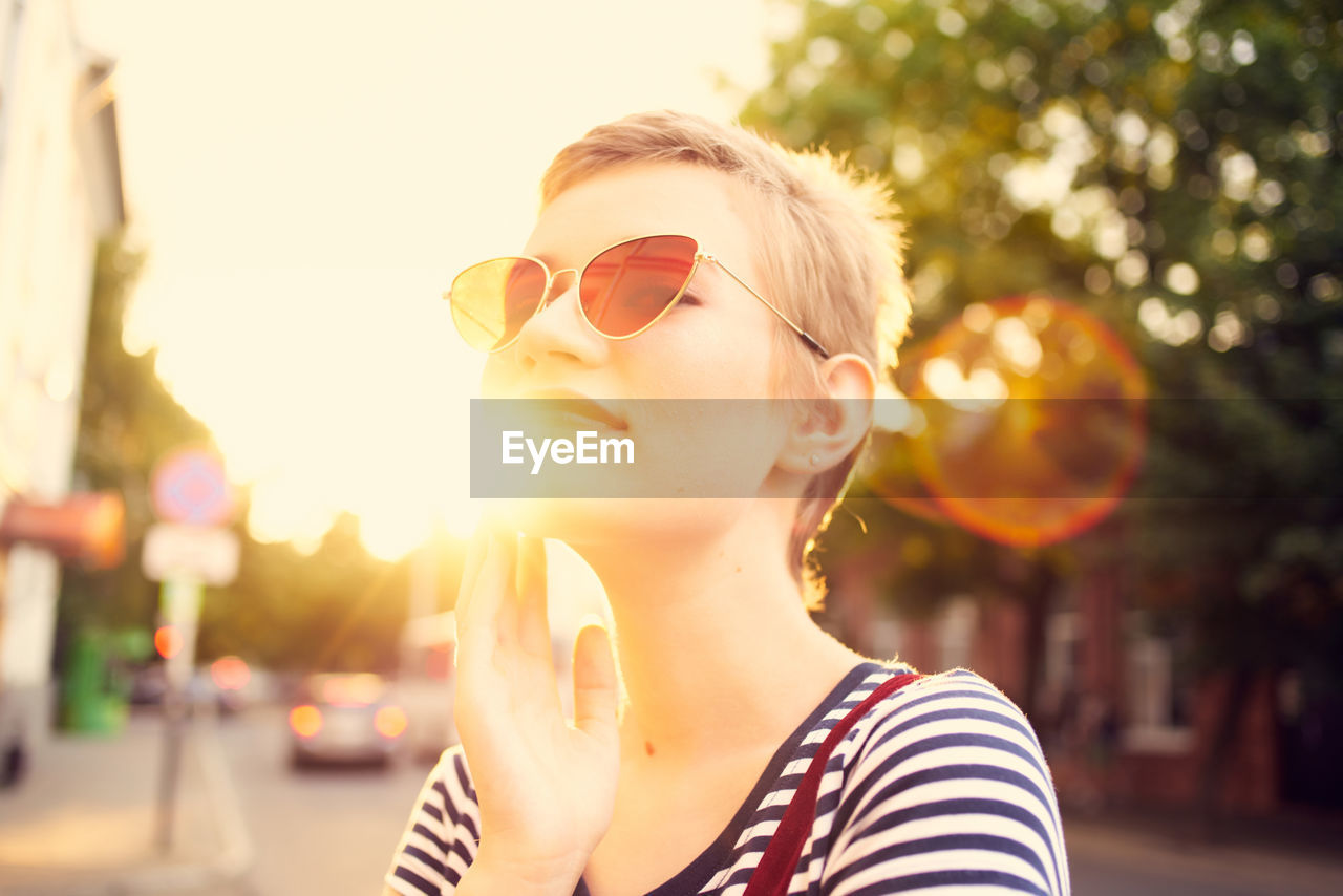 PORTRAIT OF YOUNG WOMAN WITH SUNGLASSES