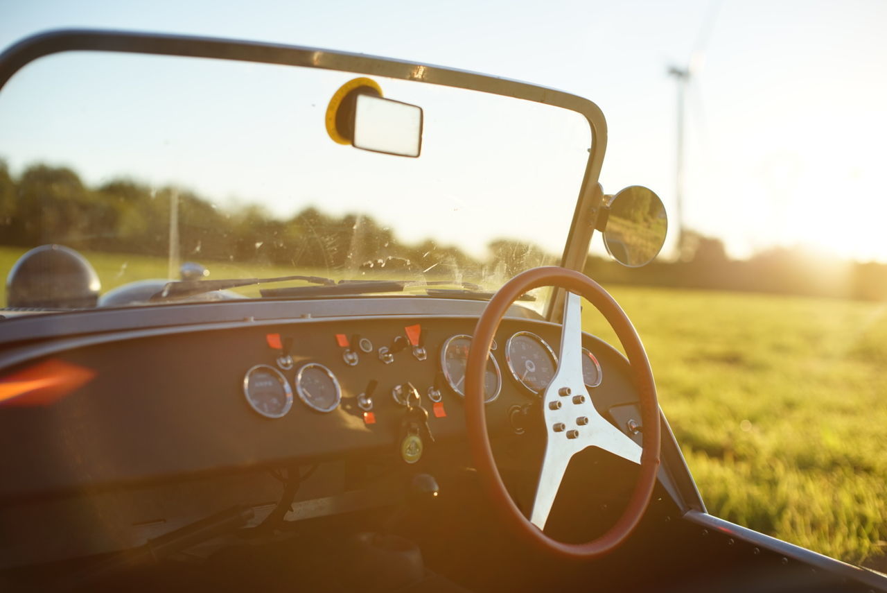 Vintage car on grassy field against sky