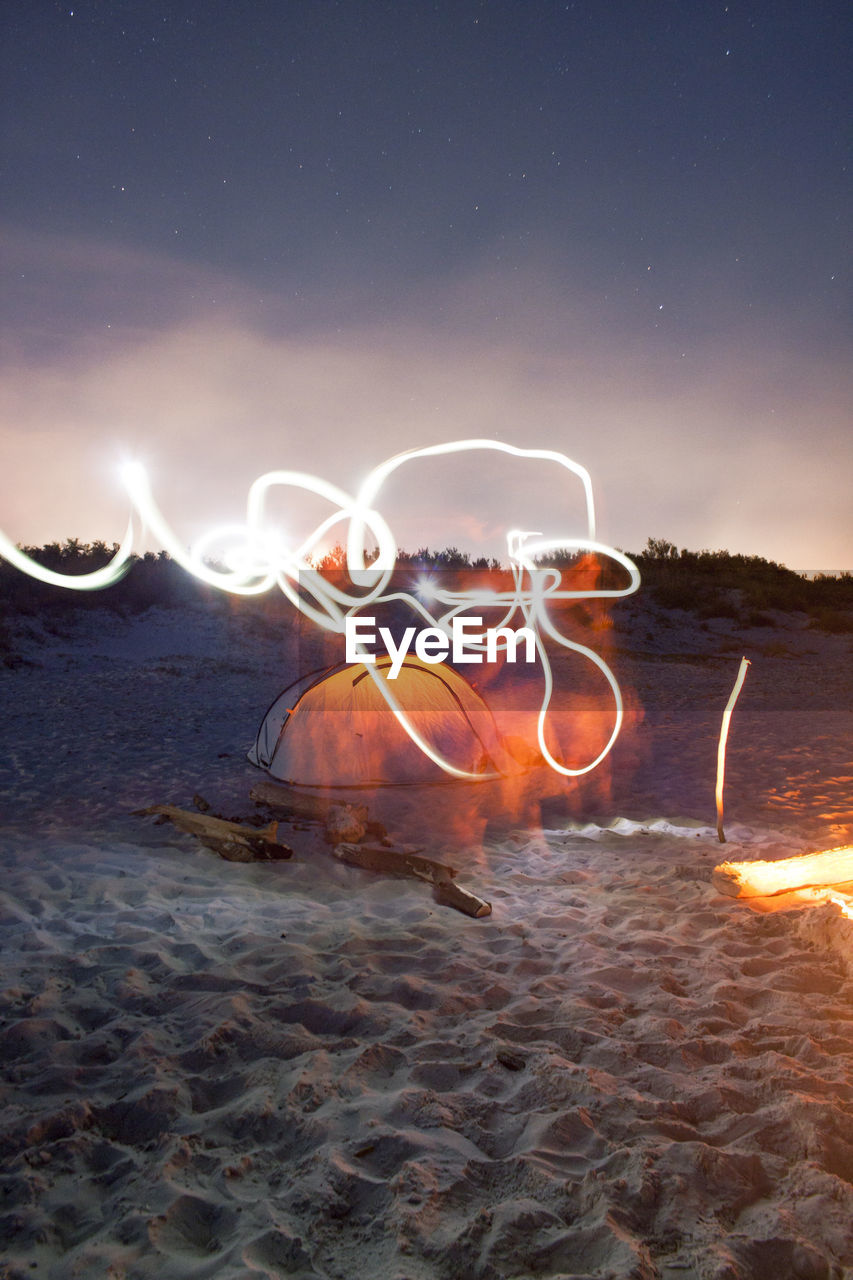 Digital composite image of light trails on beach