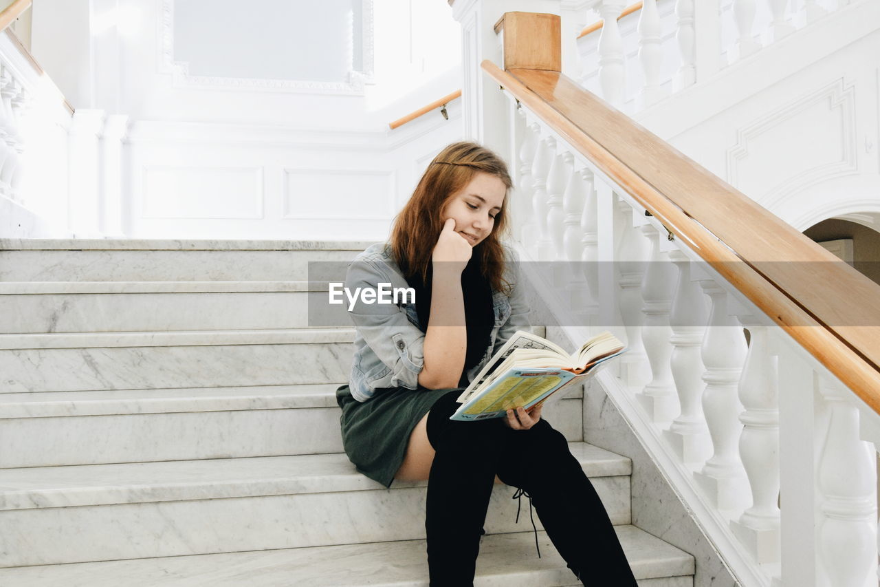 Young student reading on stairs