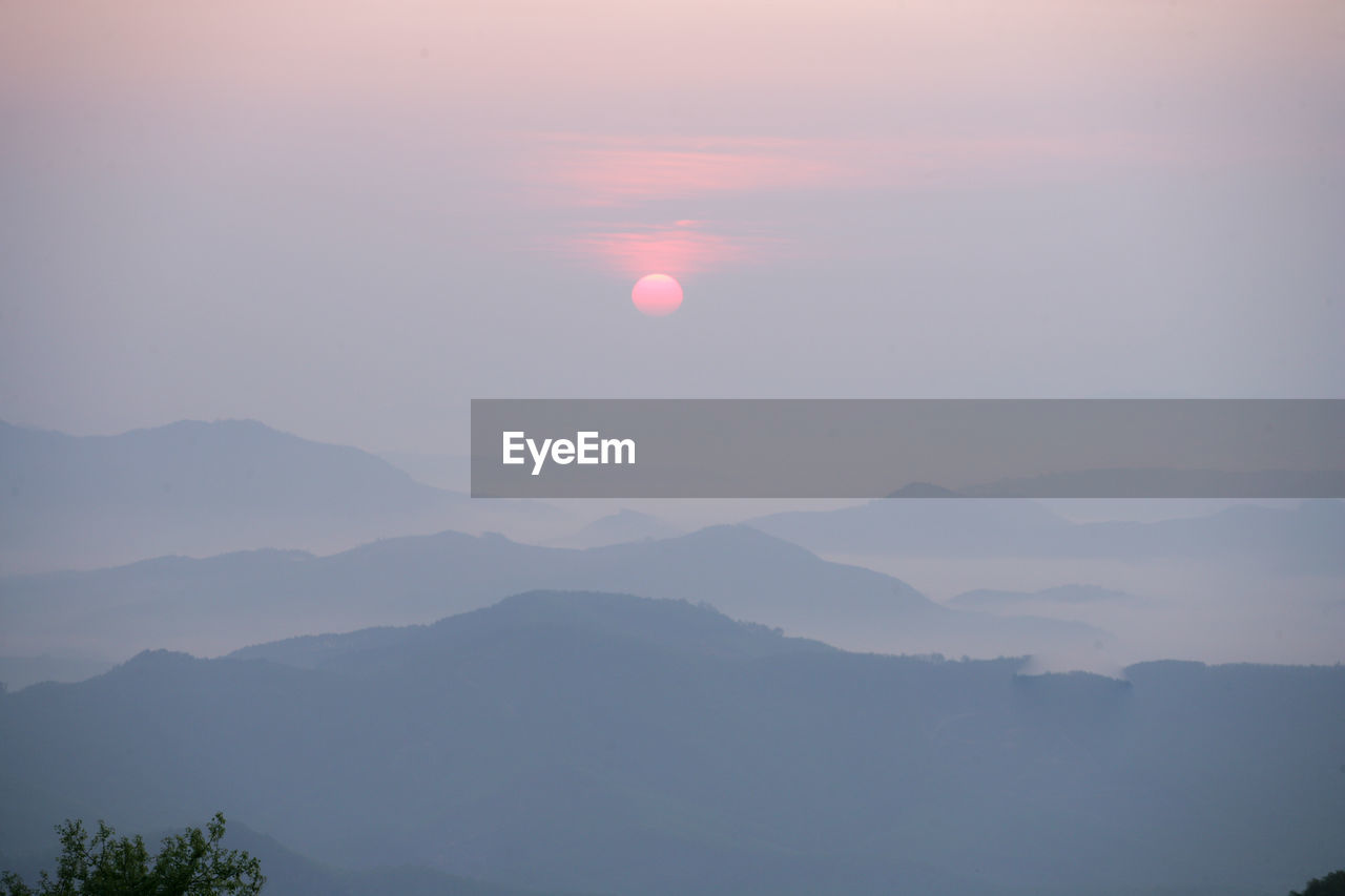 SCENIC VIEW OF MOUNTAINS AGAINST SKY AT SUNSET