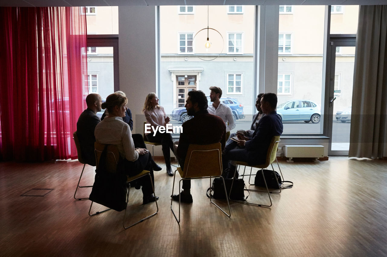 Male and female entrepreneurs sitting in circle at workplace