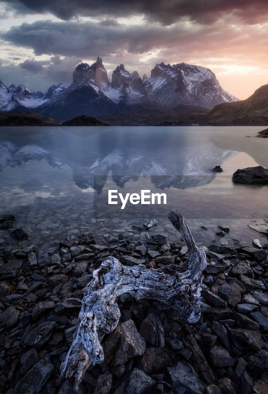 Scenic view of lake and snowcapped mountains against sky during sunset