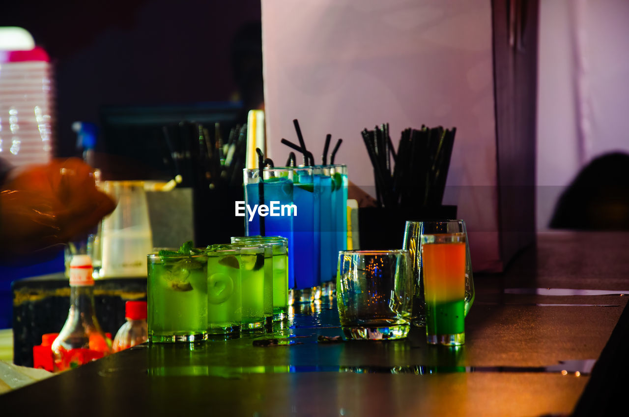 indoors, table, food and drink, container, drink, bar counter, bottle, bar, multi colored, refreshment, night, business, alcohol