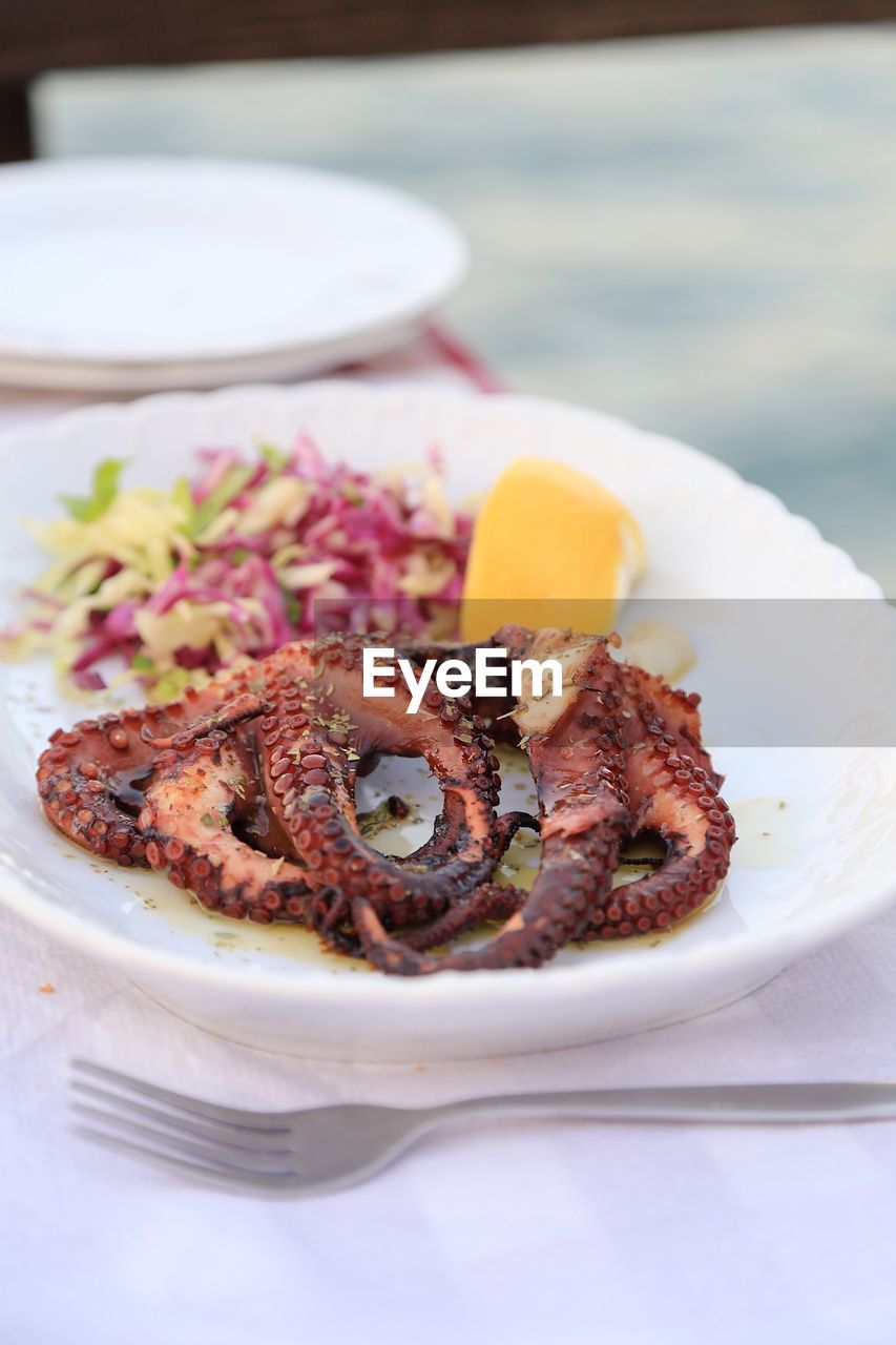 Close-up of whole grilled octopus in plate on table