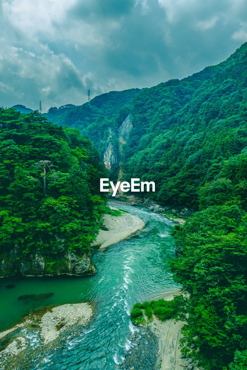 Scenic view of river amidst mountains against sky