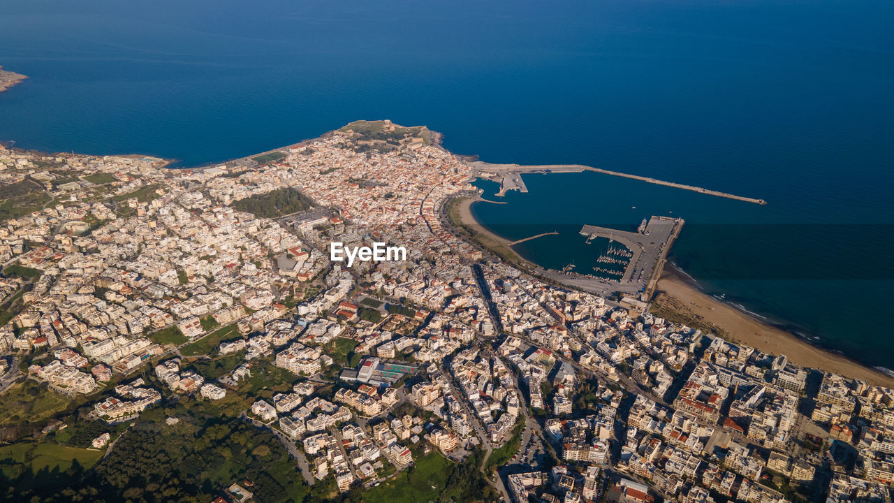 High angle view of townscape by sea against sky