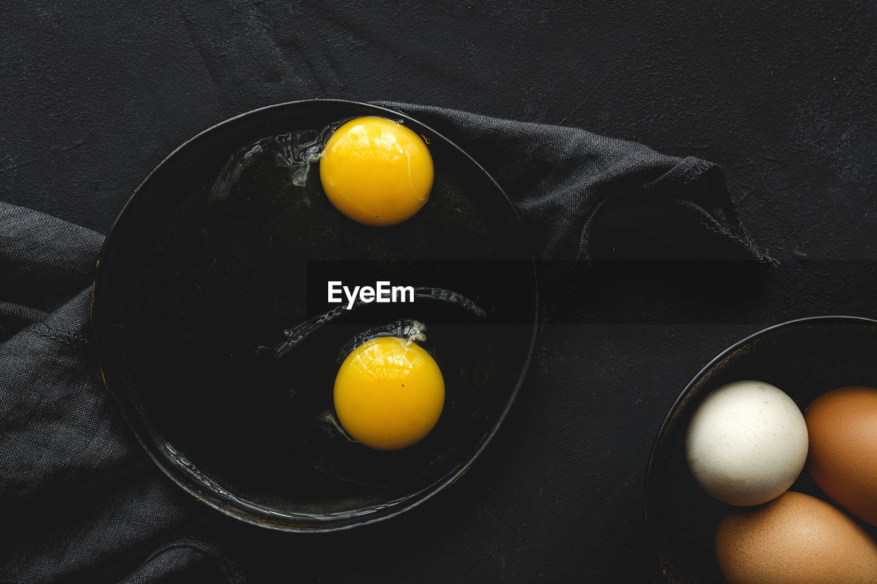 HIGH ANGLE VIEW OF YELLOW EGGS IN CONTAINER