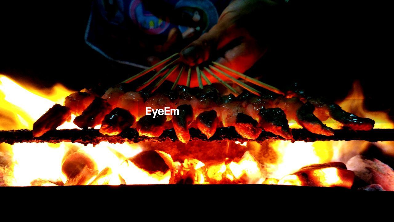 CLOSE-UP OF MAN COOKING ON BARBECUE