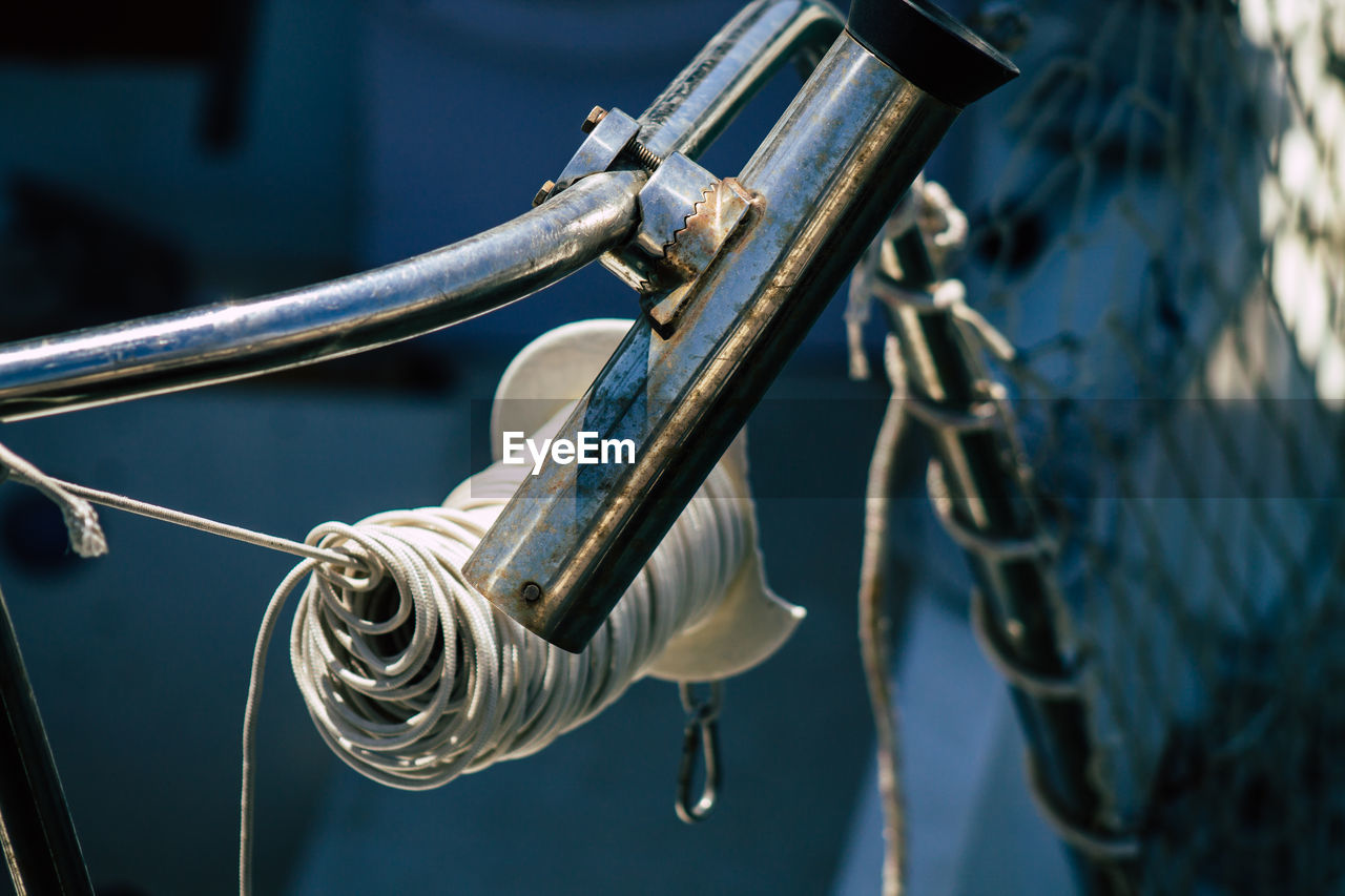 CLOSE-UP OF ROPE TIED UP ON METAL