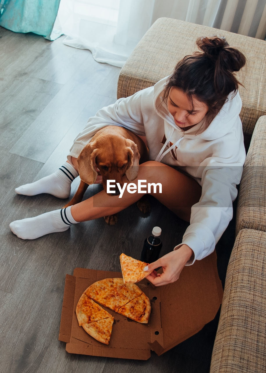 HIGH ANGLE VIEW OF WOMAN WITH DOG AT HOME