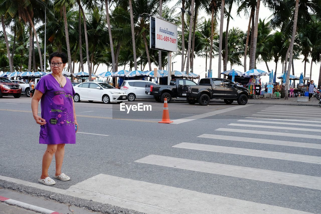 FULL LENGTH OF MAN WITH UMBRELLA ON ROAD