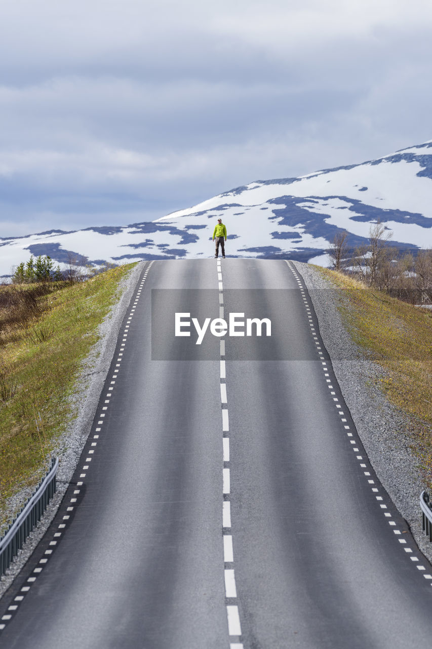 View of man standing on road against sky