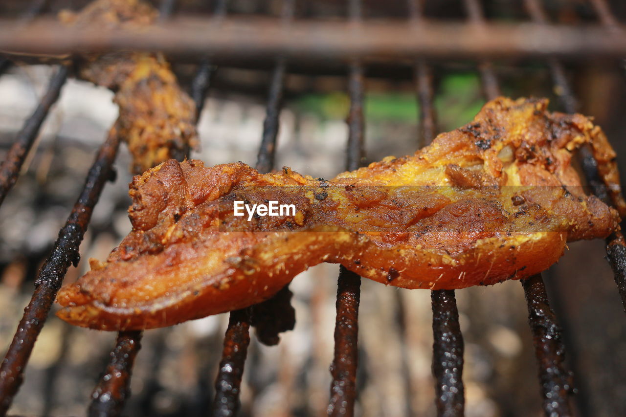 CLOSE-UP OF ROASTED MEAT ON BARBECUE GRILL