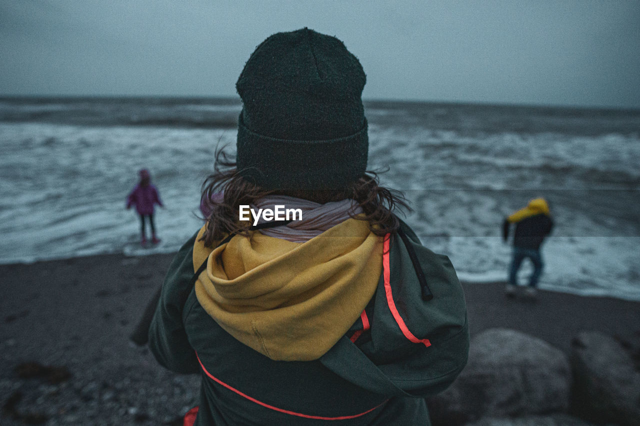 REAR VIEW OF WOMAN ON BEACH