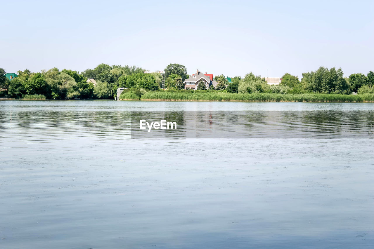 SCENIC VIEW OF LAKE BY TREES AGAINST CLEAR SKY