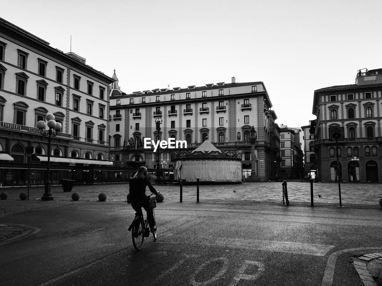 Woman riding bicycle on street against buildings