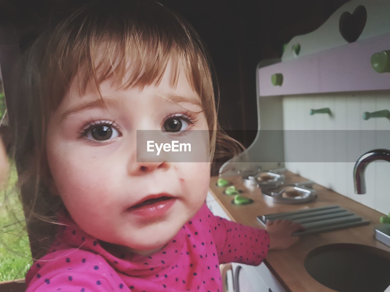 Close-up of baby girl in kitchen at home