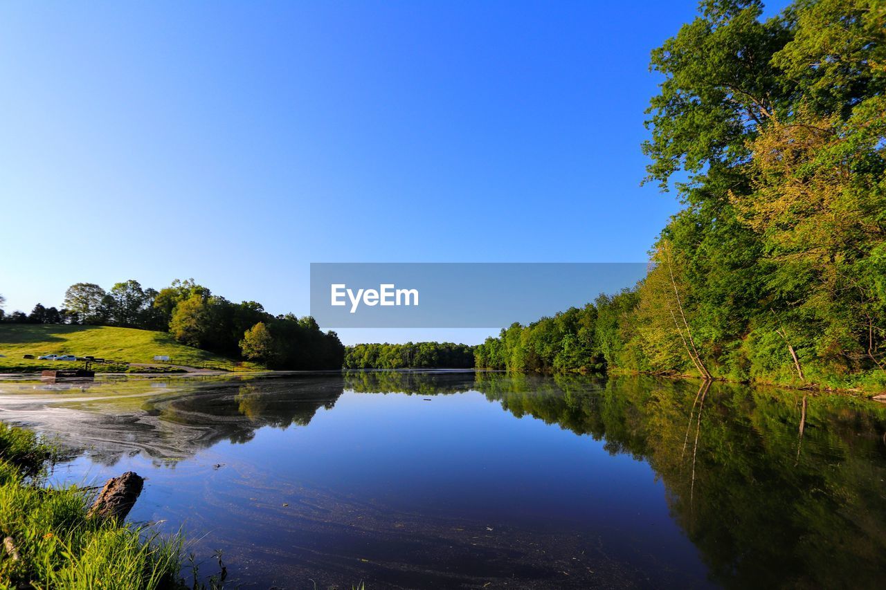 Scenic view of lake against clear blue sky