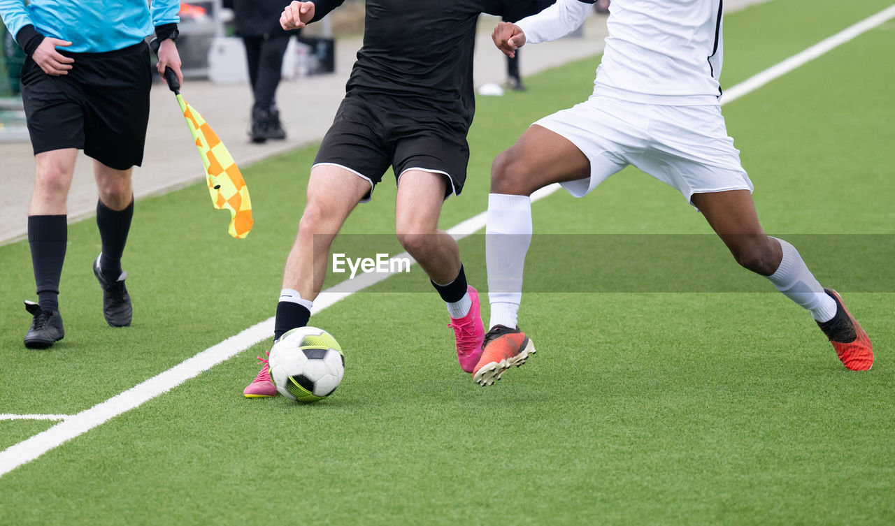 low section of man playing soccer at tennis court