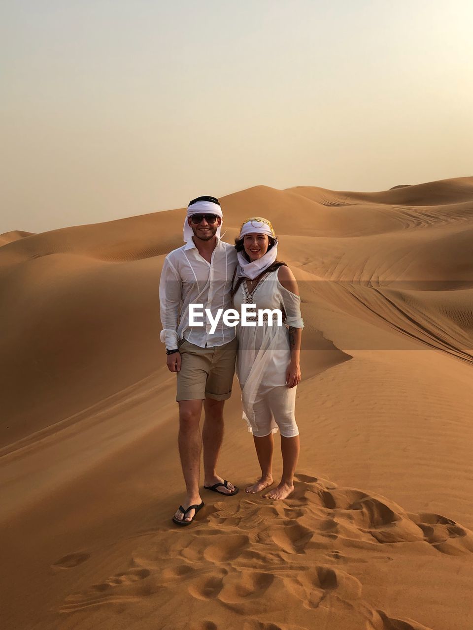 Full length of couple standing on sand dune in desert