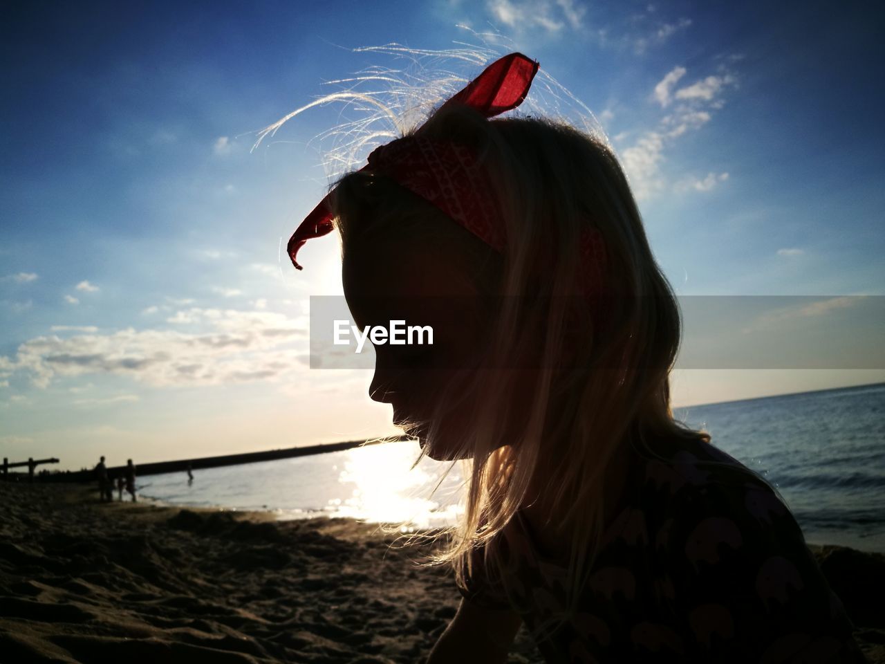 Close-up of girl at beach against sky