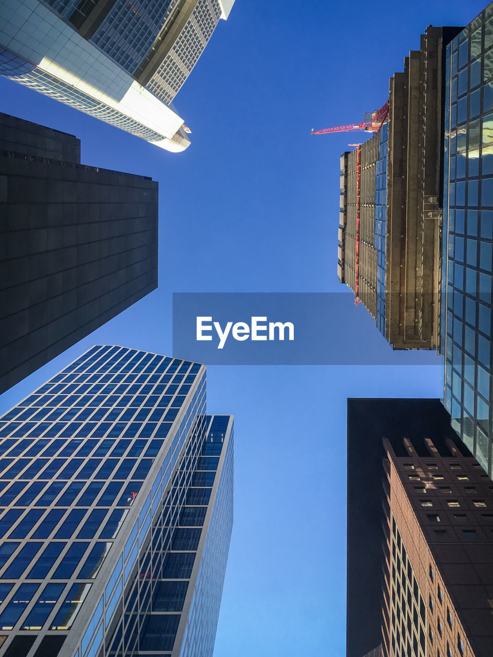 Low angle view of modern buildings against clear blue sky